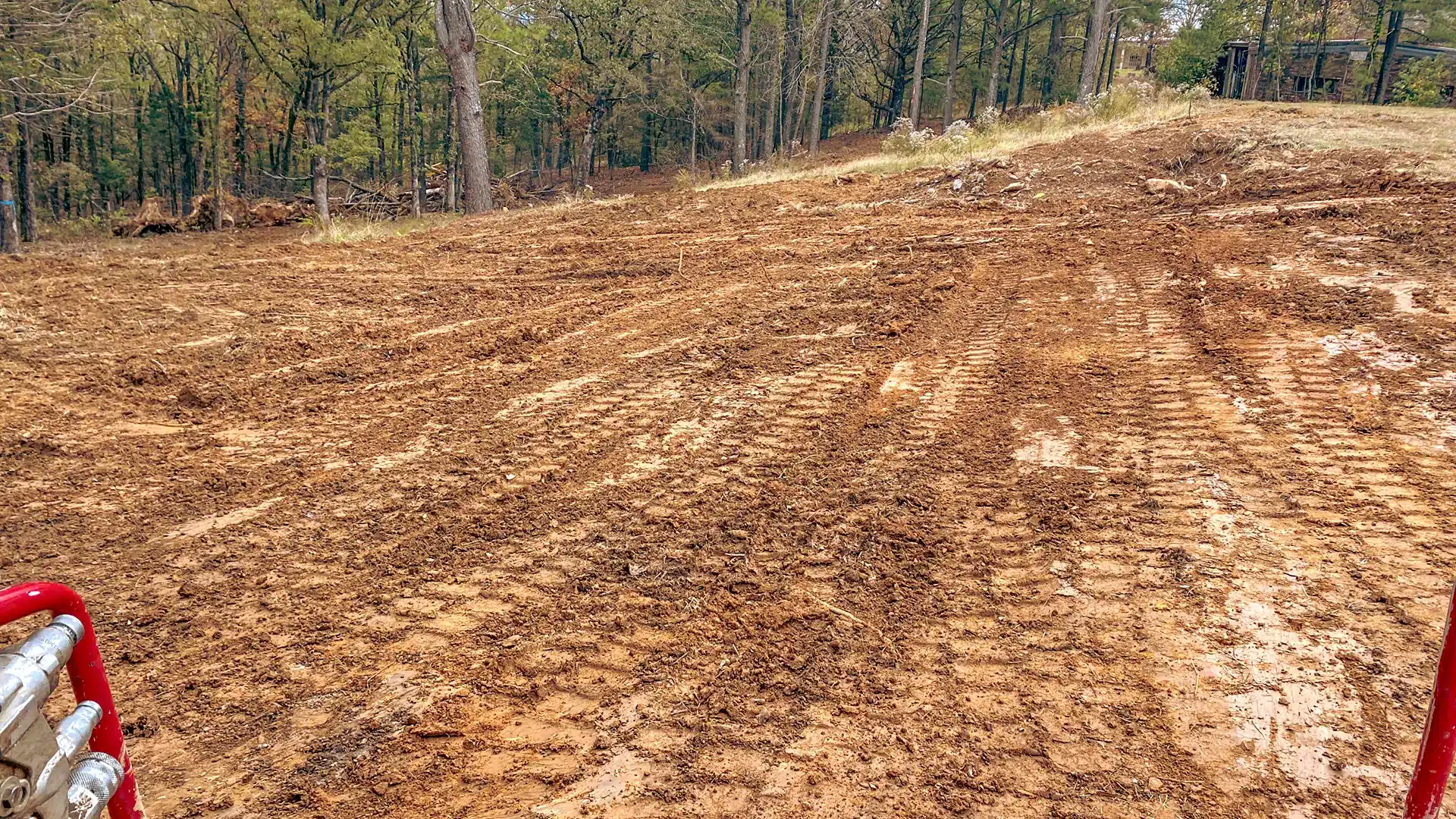 Muddy ground with equipment tracks in a cleared area